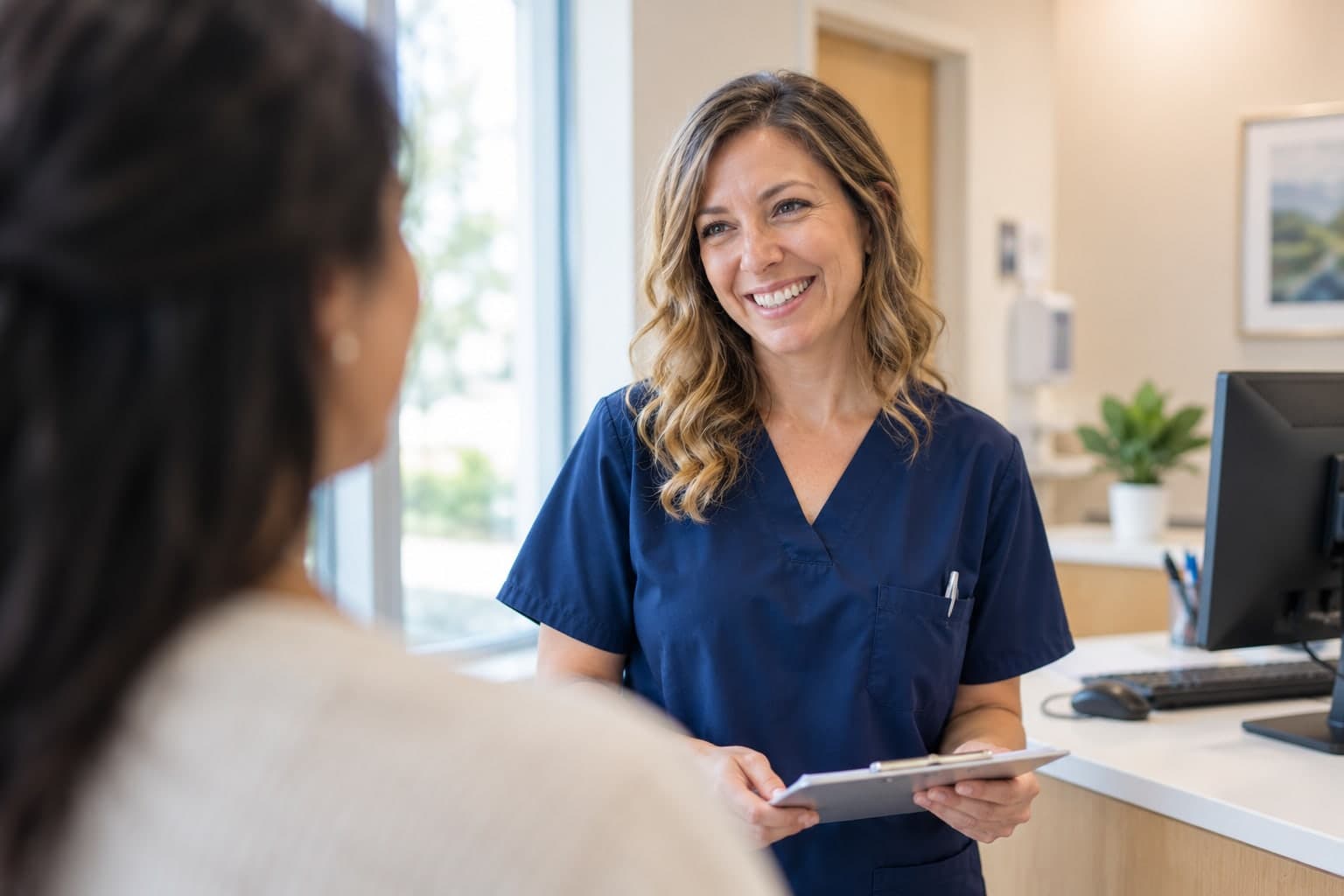 A provider talking with a patient in a bright office